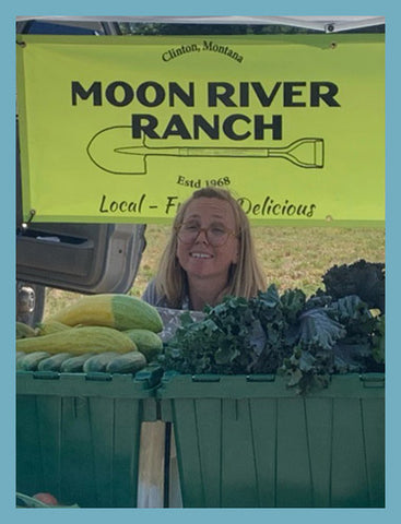 A photo of Kelly Campbell sitting. at the farmers market for Moon River Ranch