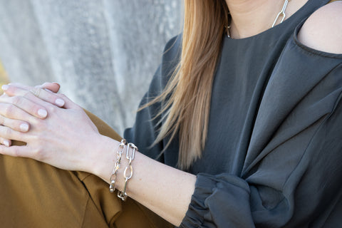 An image of a model wearing both the Greta bracelet and the Eliza bracelet, showing the newly added, proprietary carved hook closure.