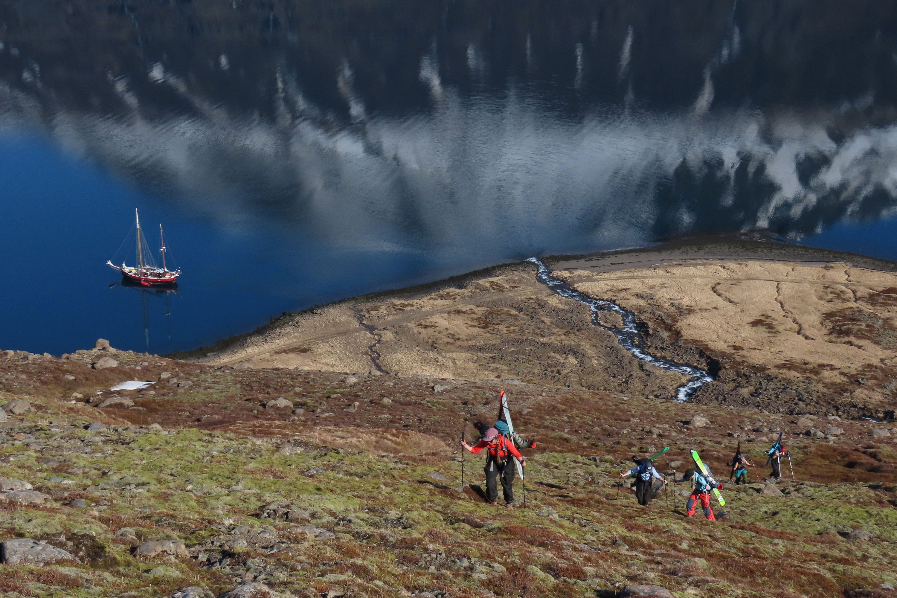 McKenna Peterson and family climbing up a mountain with their boat anchored to the shore below them