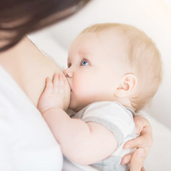 Baby with blue eyes breastfeeding