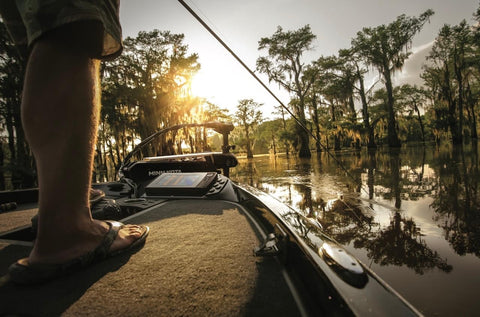 person standing on a boat casting a fishing ure