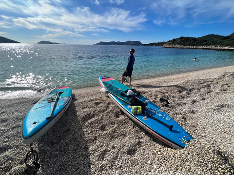 man with paddleboards looking out to sea