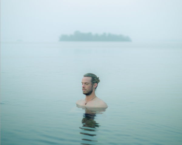 Man meditating in the sea at Dawn