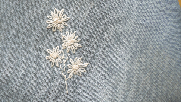 dainty wildflower embroidery on a rustic linen napkin 