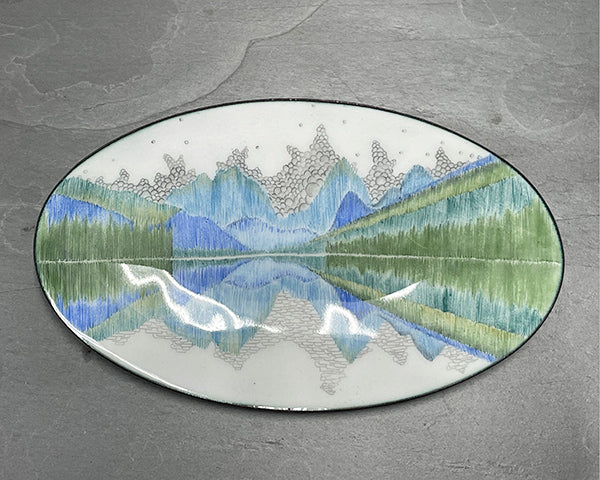 Reflect, and copper and glass enamelware oval bowl hand drawn with blue and green and black reflecting patterns by Seattle artist Catherine Grisez