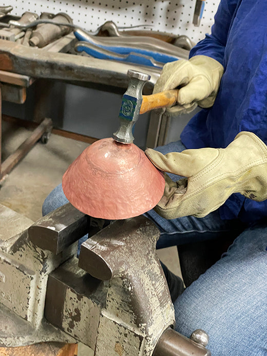 student learning to hammer bottom of copper bowl, holloware techniques taught by Catherine Grisez