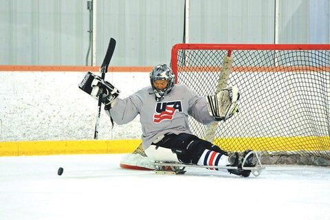 Jen Lee in front of goal during sled hockey game