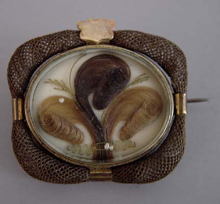 Hair work brooch with swirled hair and woven hair