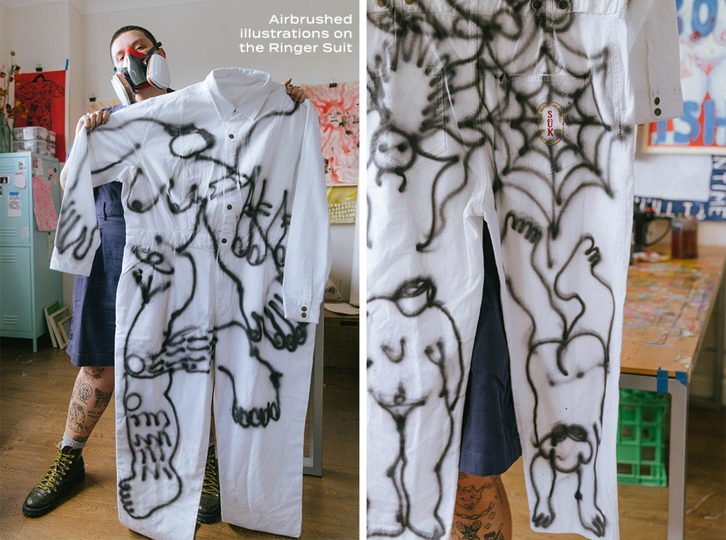 Frances poses with a white Ringer Suit. they have used an airbrush to draw illustrations of bodies and spider webs