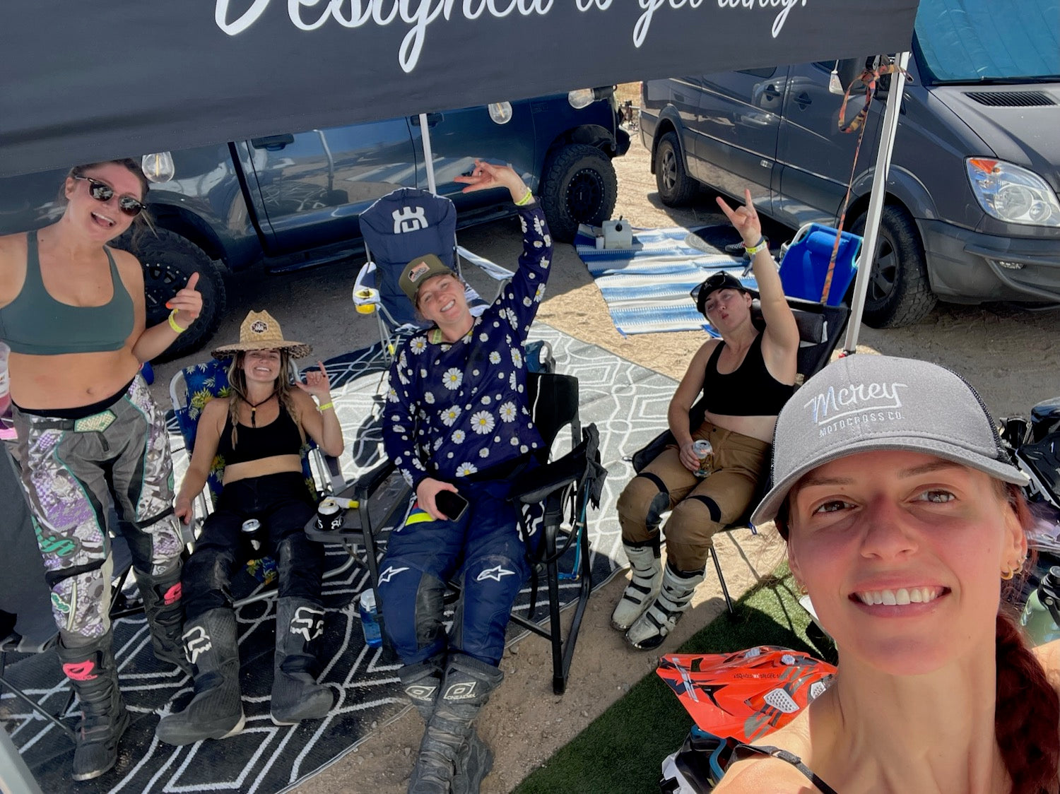 Five women sitting around a campsite after riding dirt bikes at Babes in the Dirt 2023.