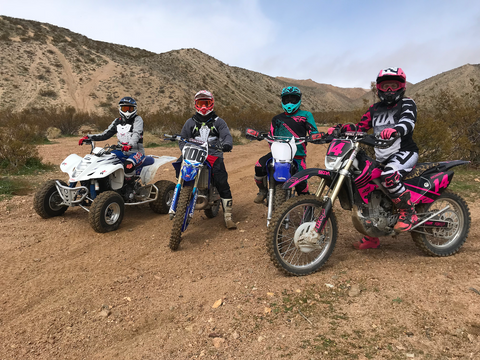 Group of four friends sitting on dirt bikes in Dove Springs