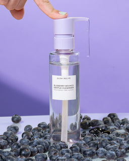 blueberry bounce gentle cleanser being dispensed and surrounded by real blueberries