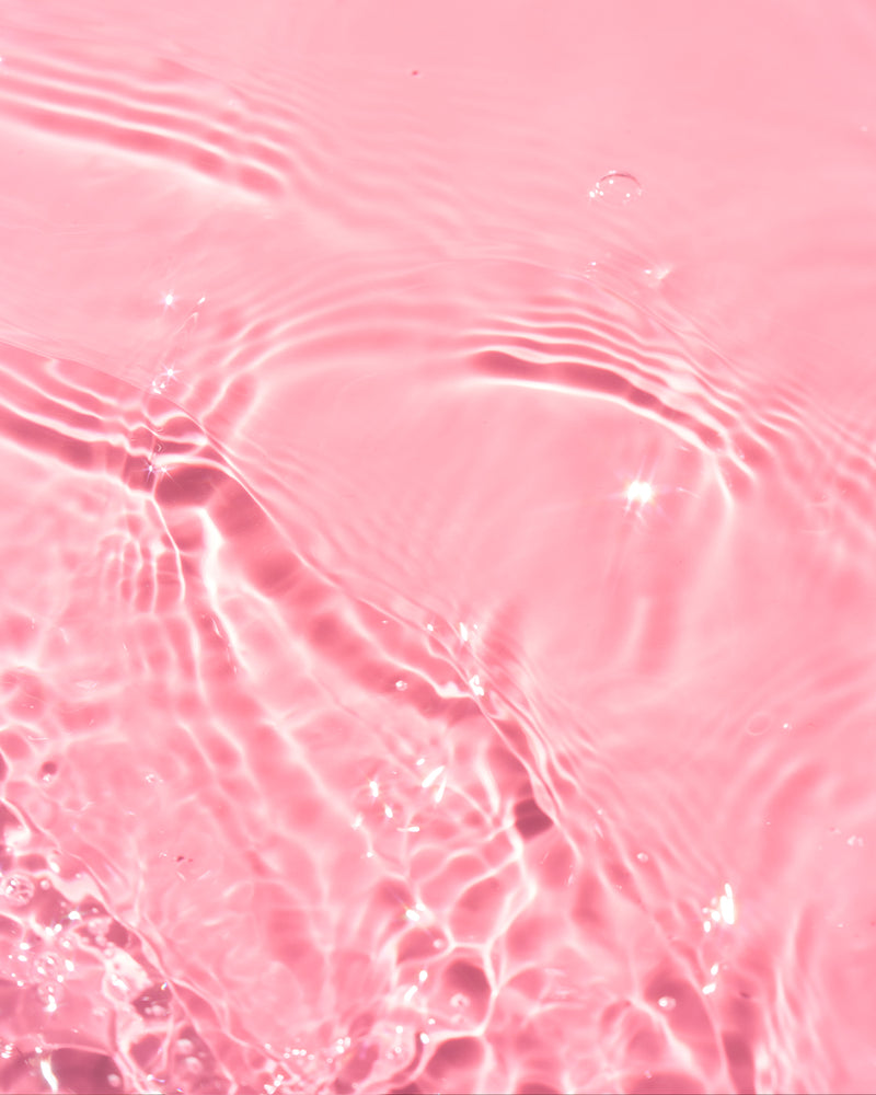 Water ripples on pink backdrop texture shot