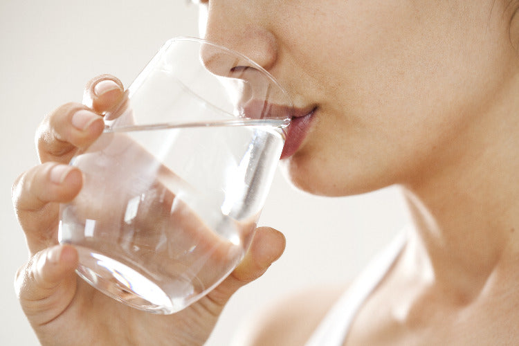 L'eau est bue par la main du visage découpé d'une femme