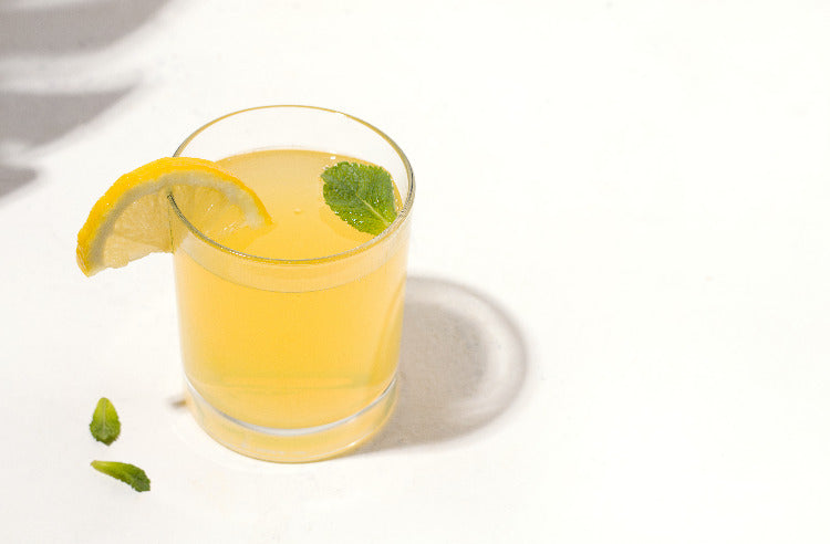 Crystal glass with kombucha lemon slice mint leaves