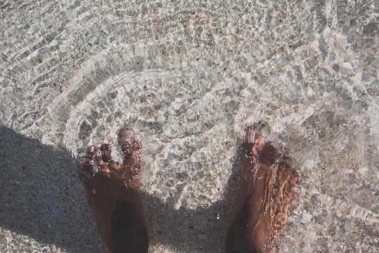 Pieds dans le sable de l'eau de mer