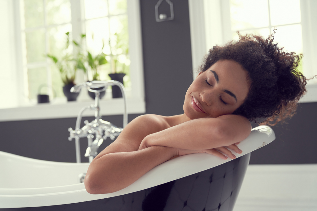 young black women pausing her pain in cbd epsom salt bath for holidays