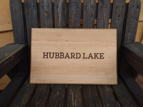 Customer's cabin lake name on a handcrafted cutting board handcrafted and engraved by Springhill Millworks using locally sourced hardwood in Michigan.