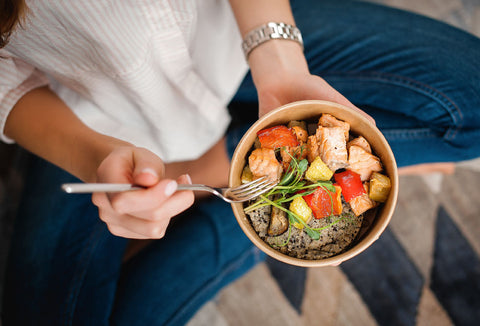 Mulher segurando bowl com alimentos saudáveis