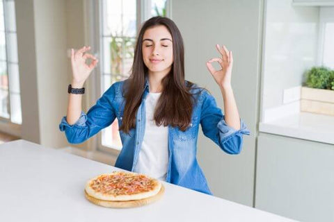 Mulher meditando antes de comer pizza