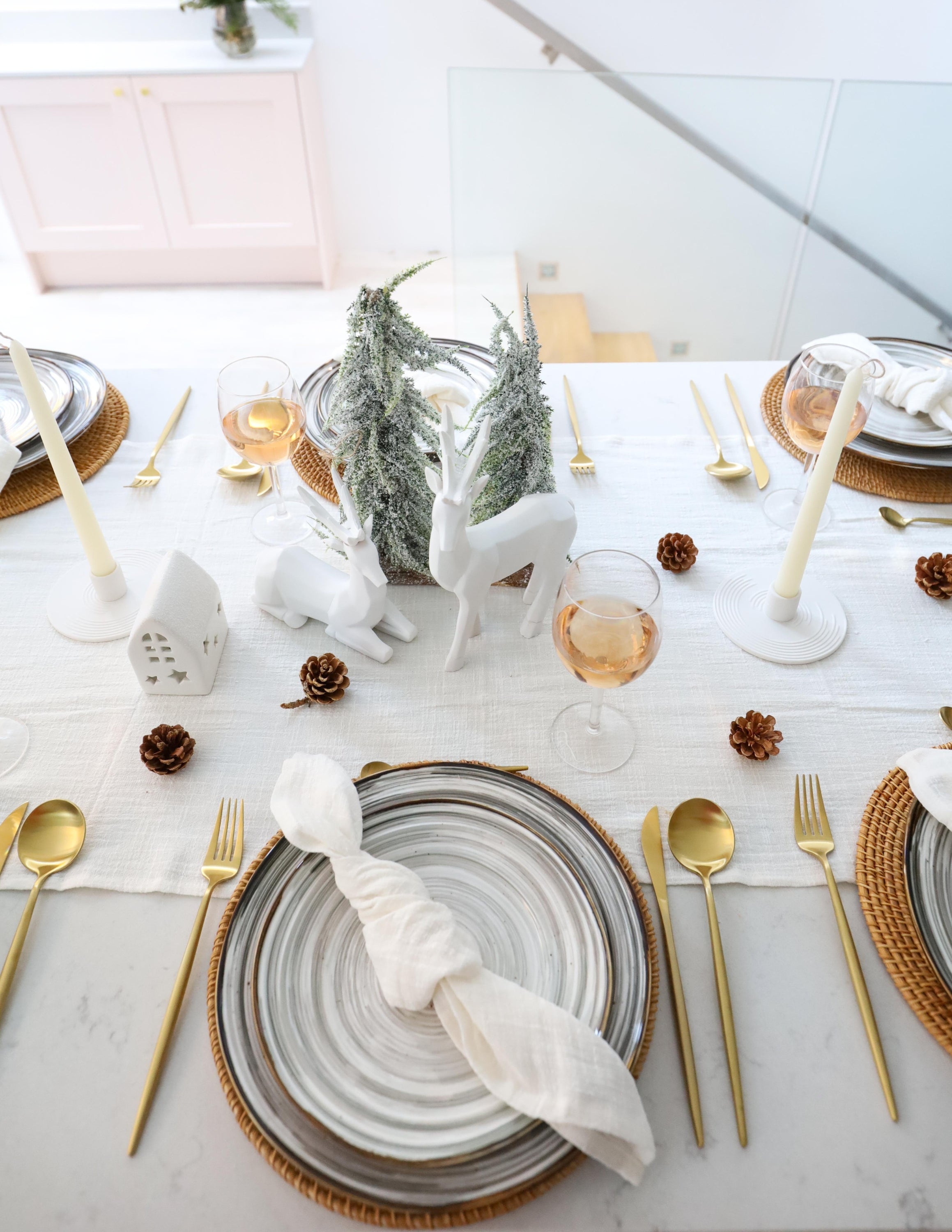 What a Host Home Decor: Christmas Tablescape With Geometric Decorative Christmas Deers, Scandi Houses, Rattan Placemats, Porcelain Plates Set Tableware, Gold Cutlery Stainless Steel Set and Rustic Cotton Gauze Table Textiles