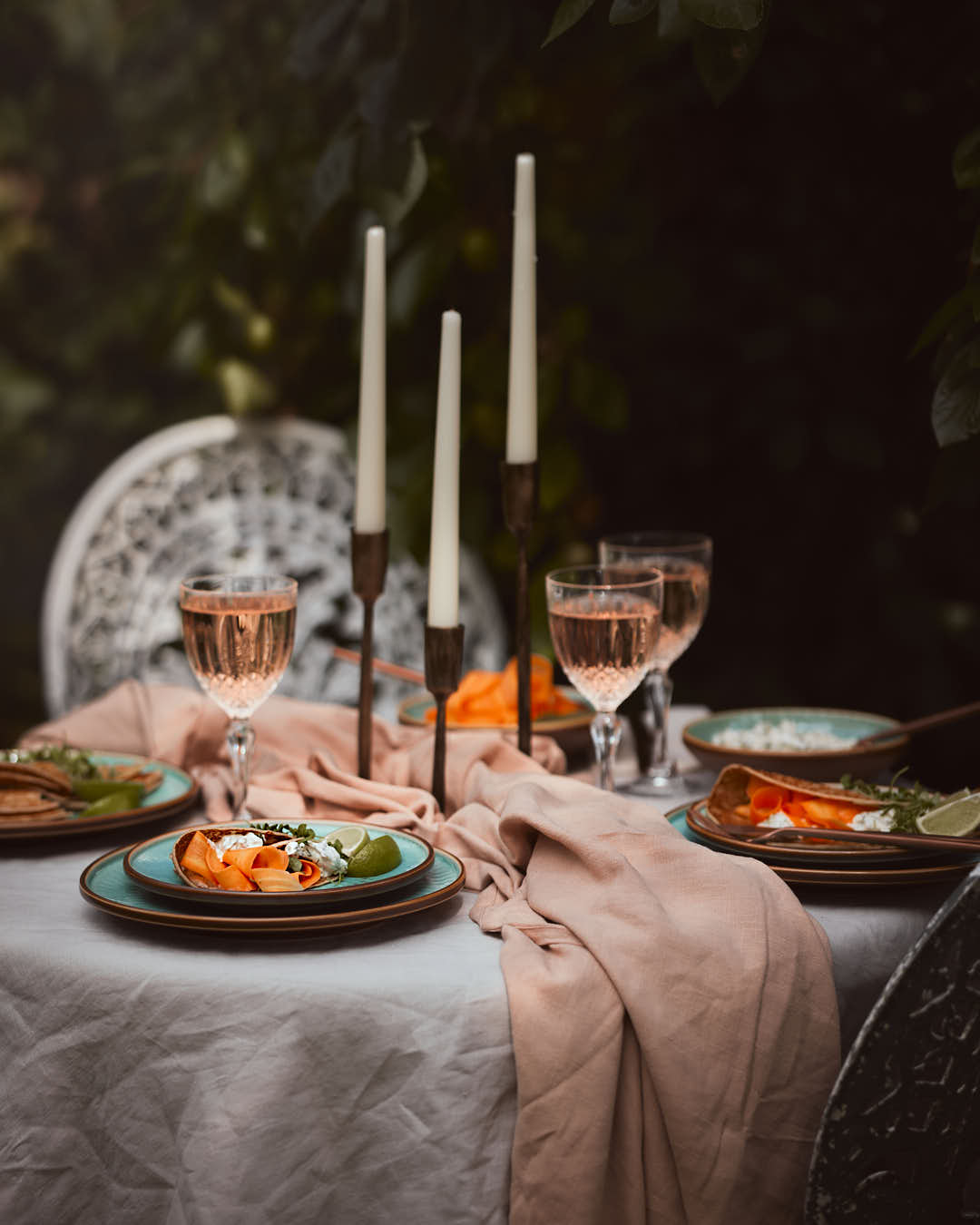 What a Host Home: antique gold brass candle holders, green porcelain plates and blows blended with touches of earth tones, washed linen table textiles (natural material tablecloths and linen napkins) and gold rose cutlery sets.