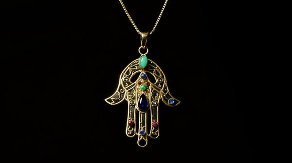 A vibrant piece of jewellery showcasing the Hamsa Hand symbol, widely used to ward off the evil eye and attract good fortune.