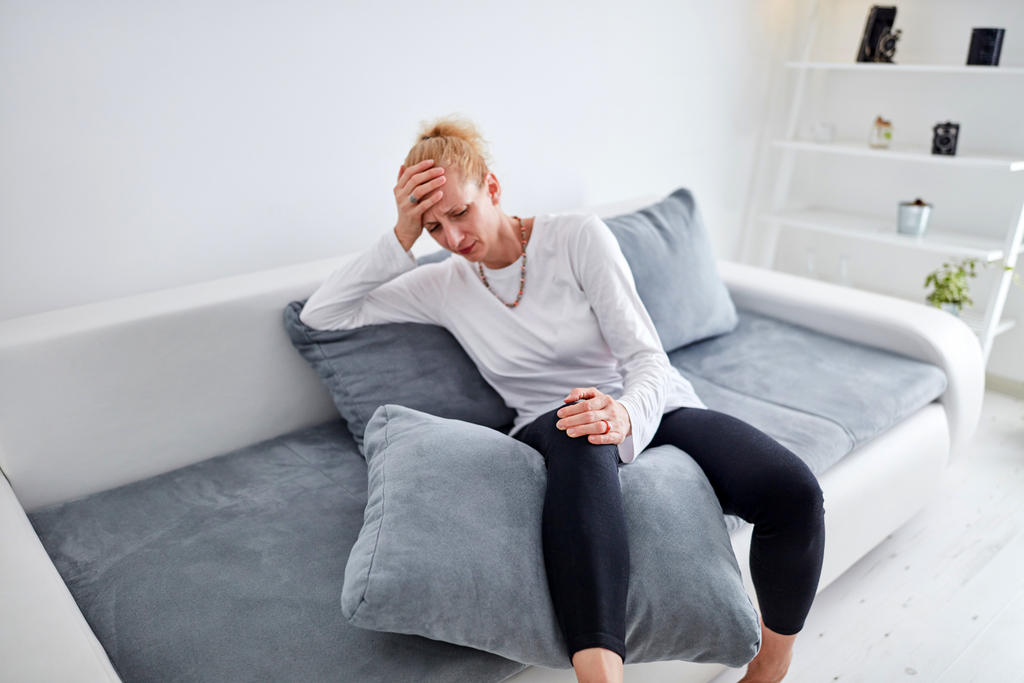 woman in pain on couch after being injured