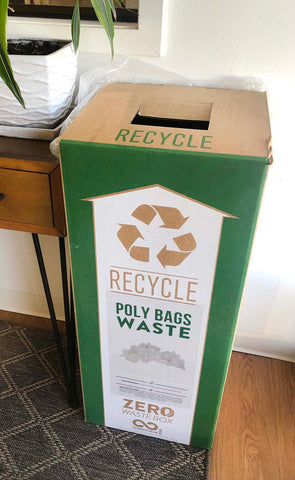 A poly bag waste recycle box sits in an entryway