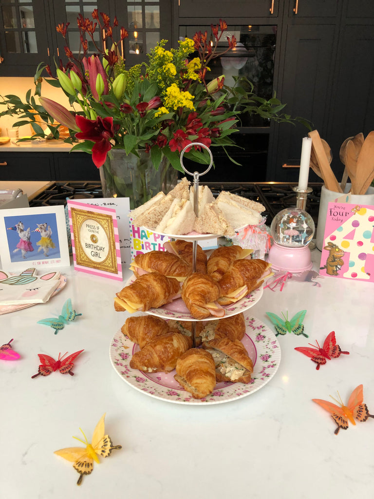 Afternoon tea-styled table with croisants and sandwiches.