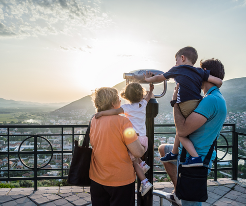 Family looking through a telescope on a family vacation.