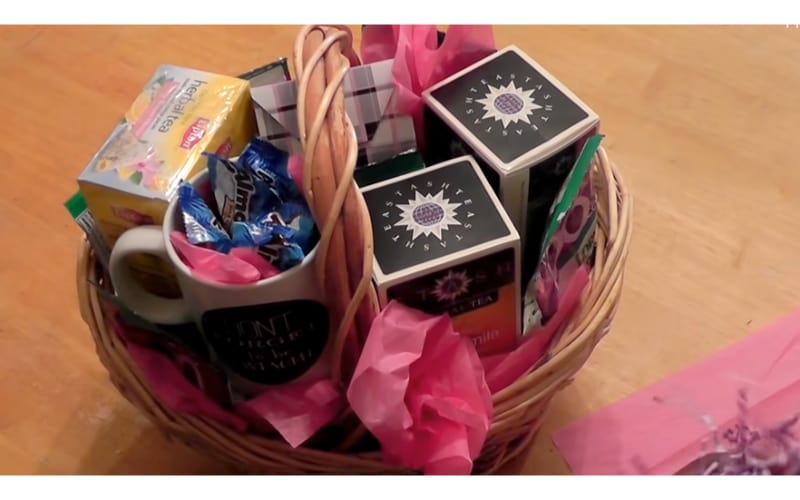 tea-themed gift basket filled with tea, mug, and treats