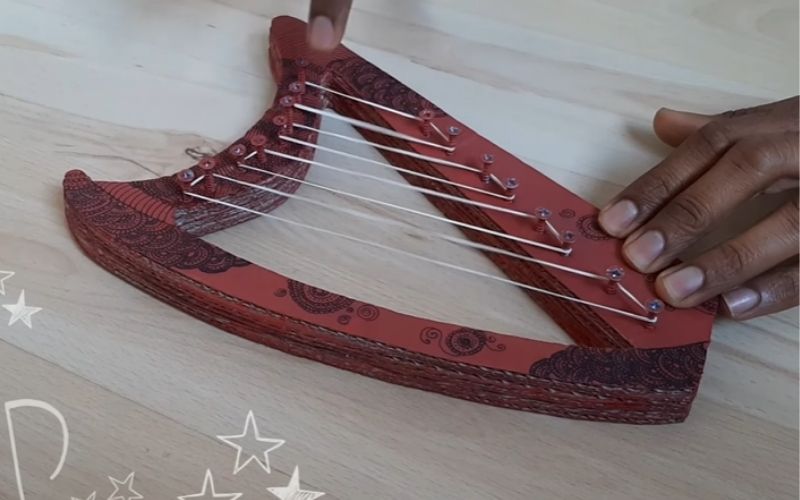 Makeshift harp made with cardboard and rubber bands