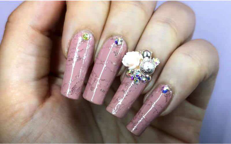 nails with pink polish and rhinestones