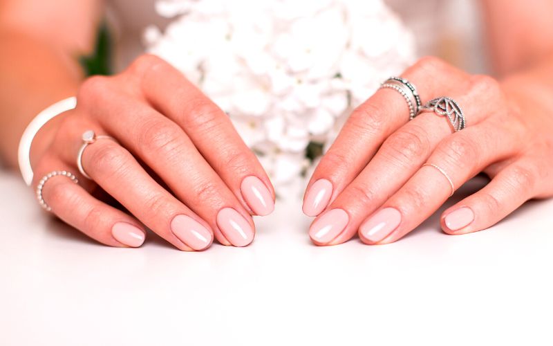 a woman's nails with a nude polish