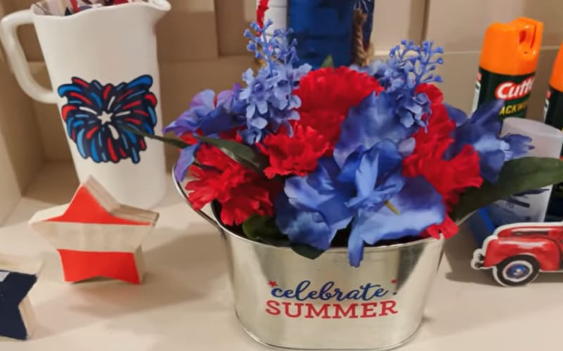 a beverage tub filled with blue and red flowers