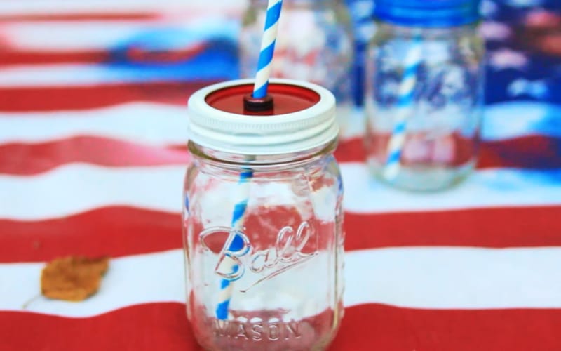 a DIY mason jar cup painted with red and white on the lid