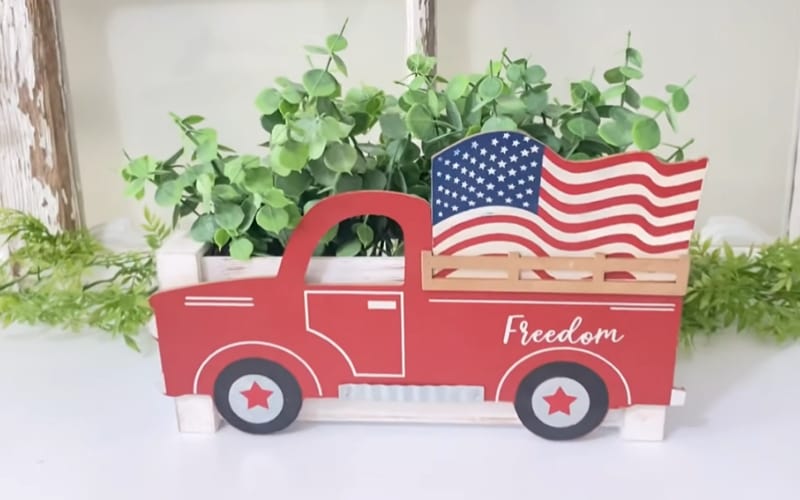  a planter box decorated with a red vintage truck 