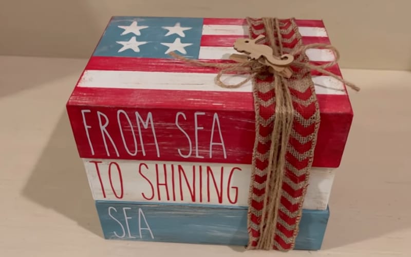 a stack of books made from wooden trays and painted with patriotic colors