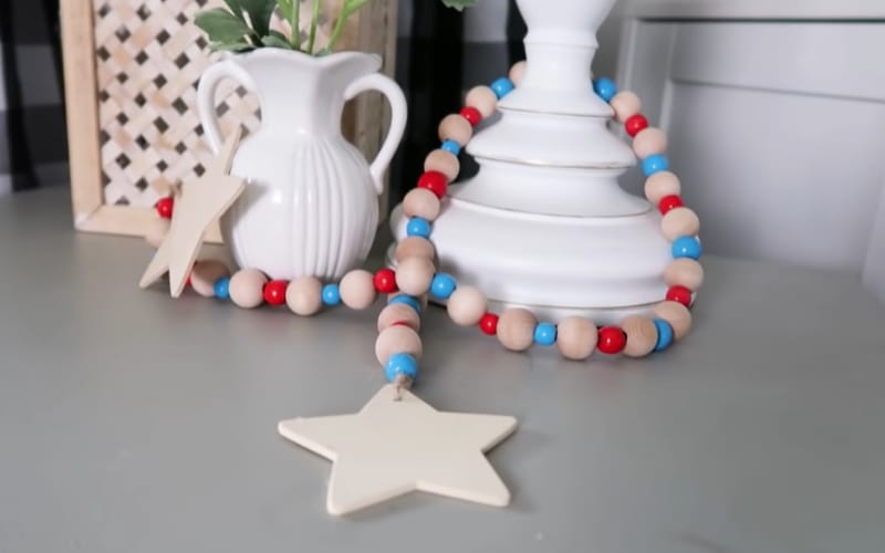 a string of patriotic beads with star ends around a white decorative vase