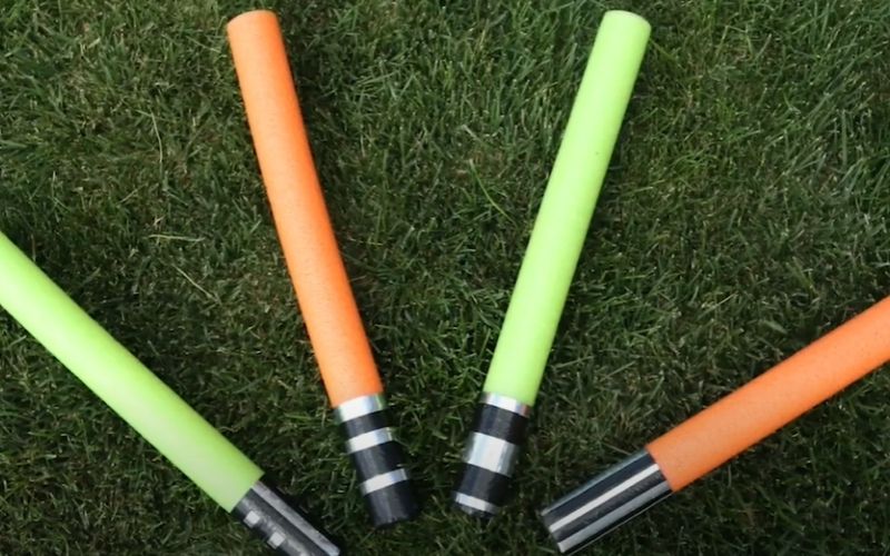 different colors of noodle lightsaber on the grass