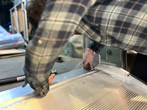 Image of a fitter installing the folding van ramp to the fixed ramp plate in a van.
