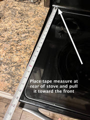 How to measure a noodle board, stove top cover. Picture showing the hook end of the tape measure at the rear of the stove top and pulled forward.