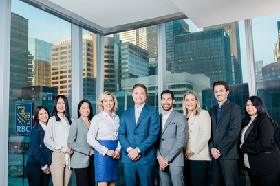 Group photo of nine professionals posing in a bank-like setting. Smartly dressed individuals presenting a professional image for RBC