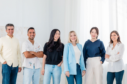 A group of six professionals, including 4 females and 2 males, standing and posing with smiles. The image captures a friendly and professional atmosphere.