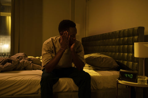 person sitting bedside at late hour