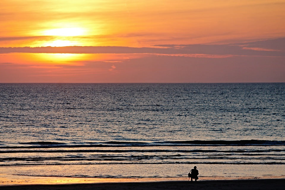 A photographer on a beach during sunset