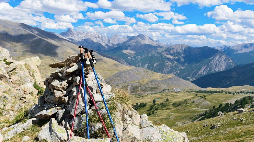 Walking poles by rocks at the top of a hill