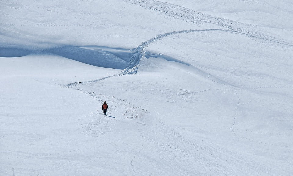 A person hiking through a snowy hill