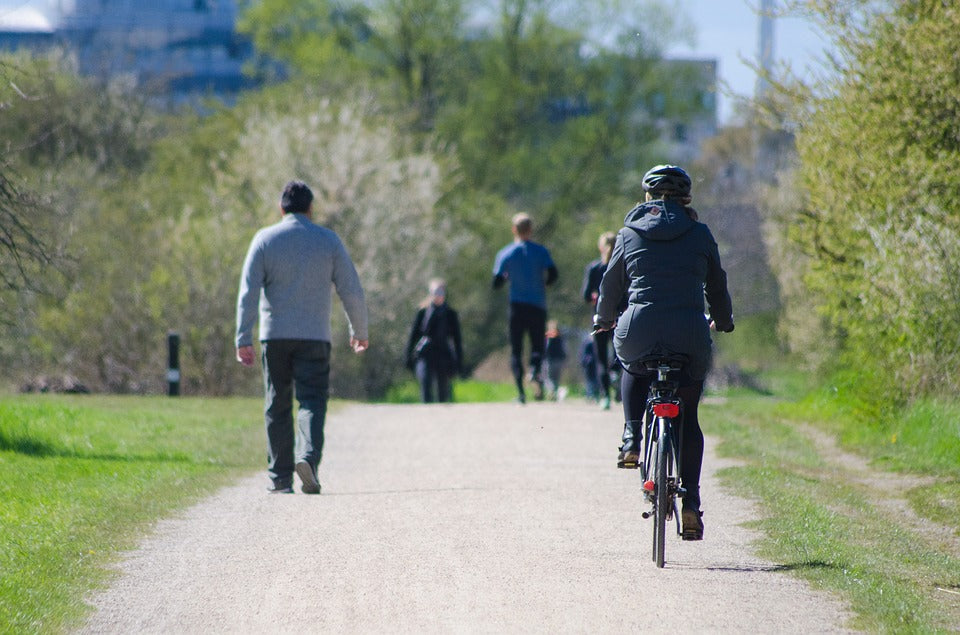 People walking and cycling on a path at a park